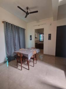 a dining room with a table and a ceiling fan at ECR 1 Spacious 3BHK Villa with Swimming pool in Chengalpattu