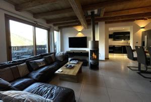 a living room with a couch and a fireplace at Le Vieux Chalet - Chalet confortable pour 8 personnes dans le cente du village MAE-3631 in Saint-Martin-de-Belleville