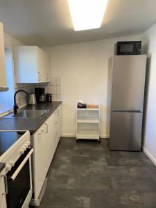 a kitchen with a refrigerator and a sink at Apartment close to the center of Aalborg in Nørresundby