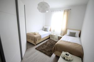 a small bedroom with two beds and a mirror at Apartments Villa Mantinela in Malinska
