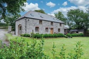 an old stone house in a field of grass at The Stables - 3 Bedroom Cottage - Beavers Hill in Manorbier