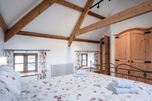 a bedroom with a bed in a room with wooden beams at The Stables - 3 Bedroom Cottage - Beavers Hill in Manorbier