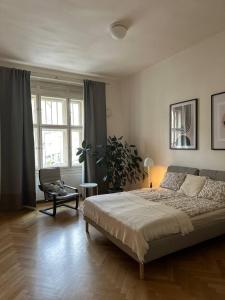 a bedroom with a large bed and a chair at Spacious Elegance - A Central Gem in Prague