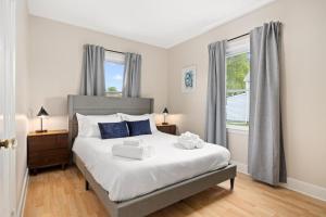 a bedroom with a large white bed with blue pillows at Cozy Mid Century Oasis with 2 KING beds in Peoria