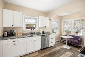 a kitchen with white cabinets and a purple chair at Tranquil 3 Bed Retreat Sleeps 7 in Peoria