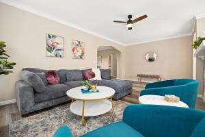 a living room with a couch and blue chairs at Tranquil 3 Bed Retreat Sleeps 7 in Peoria