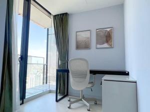 ein Schreibtisch und ein Stuhl in einem Raum mit einem Fenster in der Unterkunft Resort Living 2BR - Ultra Fast Wifii - BTS Chong Nonsi in Bangkok + 9 Fotos