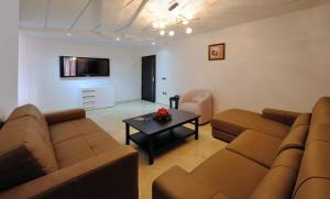 - un salon avec deux canapés bruns et une table dans l'établissement Appart Hôtel Mouna, à Marrakech