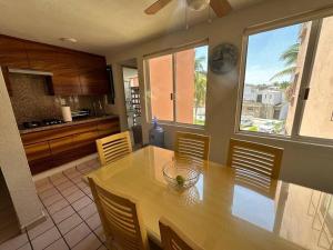 a kitchen with a wooden table and chairs and a kitchen with at Cómodo Departamento 3 Recamaras in Ixtapa