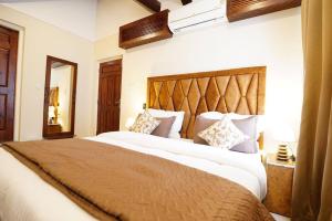una camera da letto con un letto grande in una stanza di Walisons Homestay Spirea 1 BHK plus 1 Sofa Bed Apartment a Srinagar