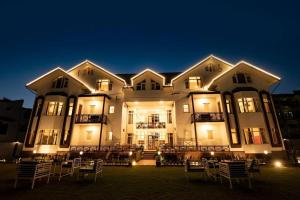 un grande edificio con delle sedie di fronte di notte di Walisons Homestay Spirea 1 BHK plus 1 Sofa Bed Apartment a Srinagar