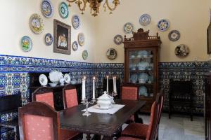 a dining room with a table and plates on the wall at Casa San José in Palma del Río