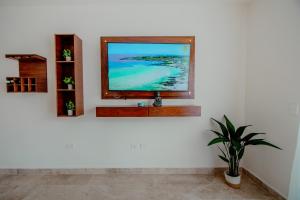 Una televisión o centro de entretenimiento en Itzamna luxury condos whit ocean viewpool