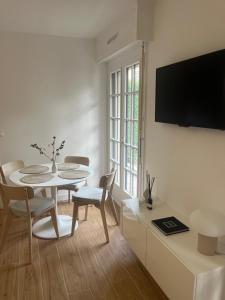 a white living room with a table and chairs at Le Villandry in Béthune