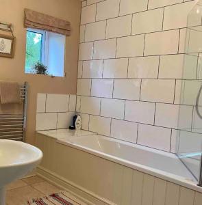 a bathroom with a white tub and a sink at Hob Lane Farm Cottage - Peak Park in Oughtibridge