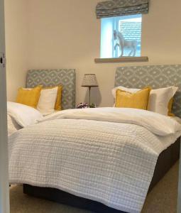 a bedroom with two large beds with yellow pillows at Hob Lane Farm Cottage - Peak Park in Oughtibridge