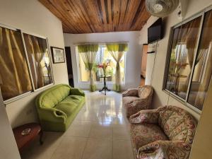 a living room with a green couch and chairs at Casa Hotel Diana Luz in Villavieja