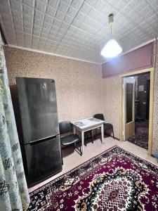 a living room with a table and a refrigerator at Однокомнатная квартира на Алмазном in Poltava