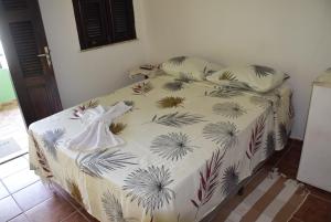 a bed in a bedroom with a white bedspread with palm leaves at Pousada Panorama do Mar in Fortaleza