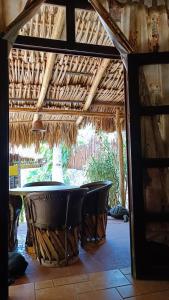 a table and chairs under a thatch roof at La casa de piedra y colores en Chichén Itzá in Chichén-Itzá