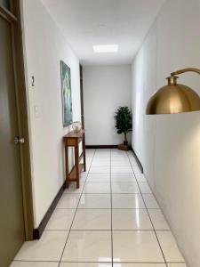 a hallway with a white tile floor and a gold light fixture at Villa Nola in Guatemala