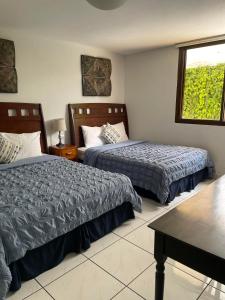 a hotel room with two beds and a window at Villa Nola in Guatemala