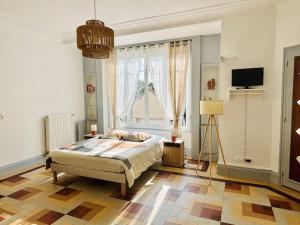 a bedroom with a bed and a large window at Le Magaline in Sainte-Savine