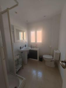 a white bathroom with a toilet and a sink at Casa Kintsugi Salamanca in Salamanca