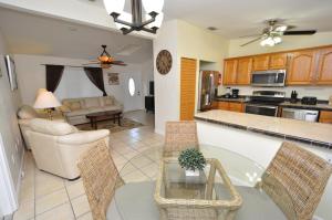 a kitchen and living room with a table and chairs at Cayman Cottage in Summerland Key
