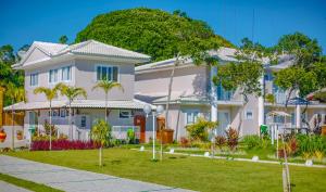 una grande casa bianca con un cortile verde di Mont Ararat Alto da Pitinga - Rede Tonziro a Porto Seguro