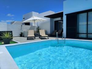 a swimming pool in front of a house at Goikiri in Playa Blanca