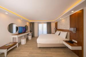 una habitación de hotel con una cama y un espejo en Marvelous Sarıgerme, en Sarigerme