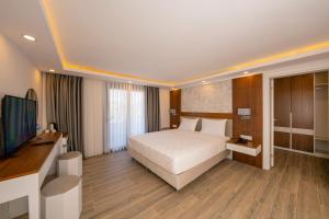 Una habitación de hotel con una cama y un televisor de pantalla plana. en Marvelous Sarıgerme, en Sarigerme 27 fotos más