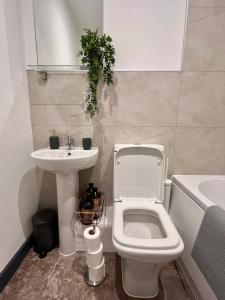 a bathroom with a white toilet and a sink at High Point 2 bed Apartment in Bradford
