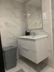 a white bathroom with a sink and a mirror at Appartement in Saint-Martin-de-Valgalgues +8 photos