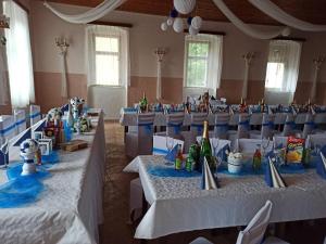 un salón de banquetes con mesas blancas y sillas azules en Penzion U Zeleného Stromu, en Telnice