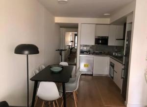 a small kitchen with a black table and white chairs at Luxury Apartment in Fuengirola +15 photos
