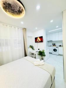 a white bedroom with a bed and a kitchen at Fuenlabrada in Fuenlabrada