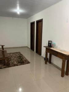 a living room with a wooden table and a rug at Vicentina Hospedagem in Tiradentes