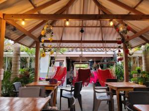 an outdoor patio with wooden tables and chairs at Hostal Hilltop Salento in Salento