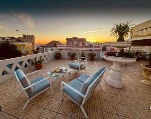 a patio with chairs and a table on a balcony at Casa Beny 1897 Guesthouse in Loulé