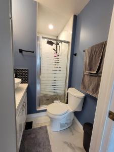 a bathroom with a white toilet and a shower at Heart to Downtown - Bright and Sunny Ultra Premium Queen bedroom in Calgary