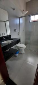a bathroom with a toilet and a sink and a shower at Bangalô 12 na praia de Guaratiba, Prado, ba in Prado +27 photos