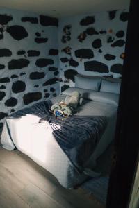 ein Bett in einem Schlafzimmer mit einer Wand mit Kuhmuster in der Unterkunft Los Amantes de la naturaleza. in Salão