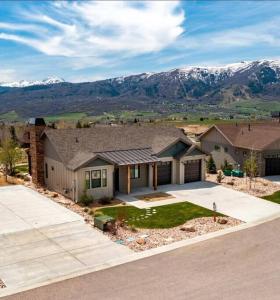 a large house with mountains in the background at Powder Mountain Escape in Eden