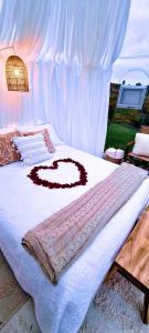 a bed with a white blanket with a heart on it at The Hunter Valley Star Gazing BubbleHotel in Mulbring
