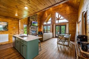 - une cuisine et une salle à manger dans une cabane en rondins dans l'établissement New 2BR with Loft Cabin by Parkway, Gatlinburg & GSMNP, à Sevierville