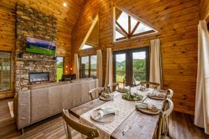 une salle à manger avec une table et des chaises et une télévision dans l'établissement New 2BR with Loft Cabin by Parkway, Gatlinburg & GSMNP, à Sevierville
