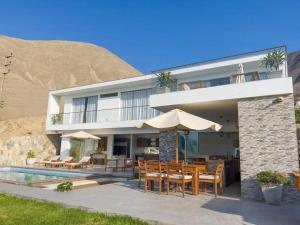 a villa with a swimming pool and a table and chairs at Casa de Campo - La Raya in Cieneguilla