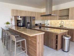 a kitchen with a large island with bar stools at Casa de Campo - La Raya in Cieneguilla